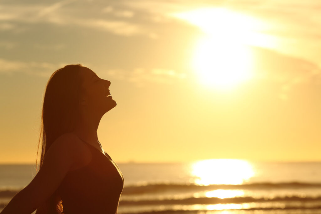 Profile Of Woman Breathing Fresh Air At Sunset