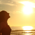 Profile Of Woman Breathing Fresh Air At Sunset