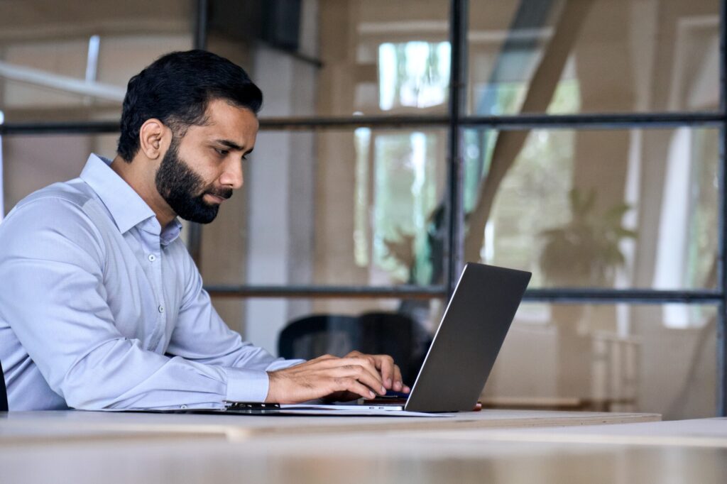 Side View Of Serious Adult Concentrated Focused Indian Hispanic Boss